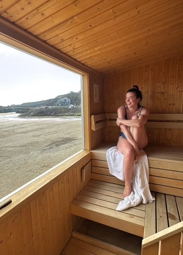 woman un sauna with view of sea,