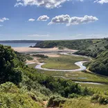 A view of a sandy beach and cliffs on a sunny day.